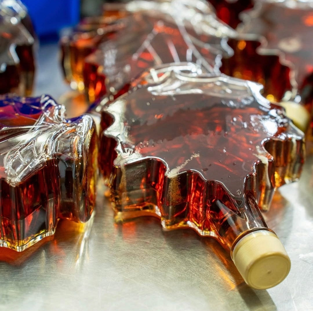 Autumn maple leaf bottle of pure maple syrup after canning process in sealed glass bottle