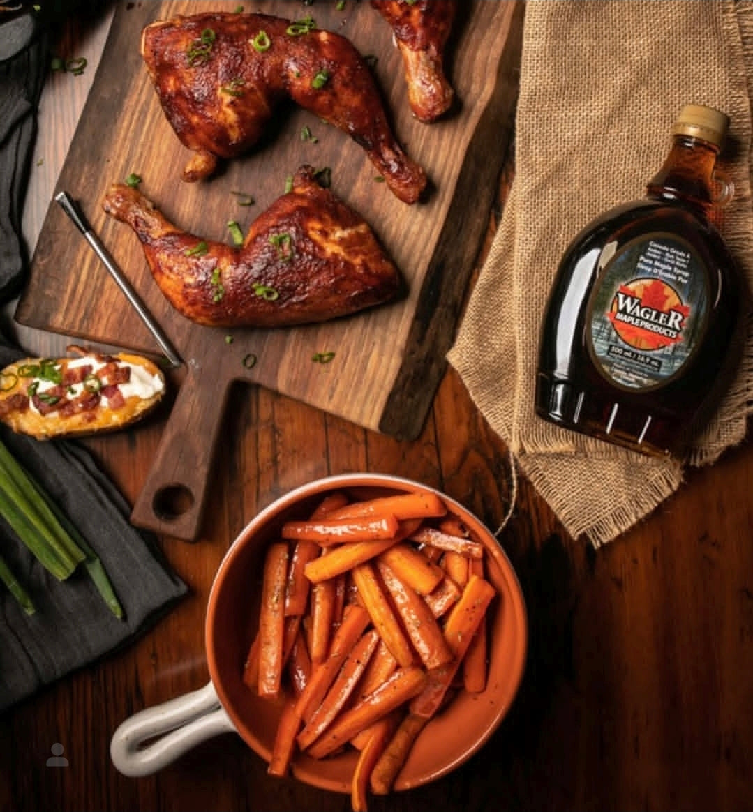a glass bottle of pure Ontario maple syrup displayed with grilled chicken and veggies