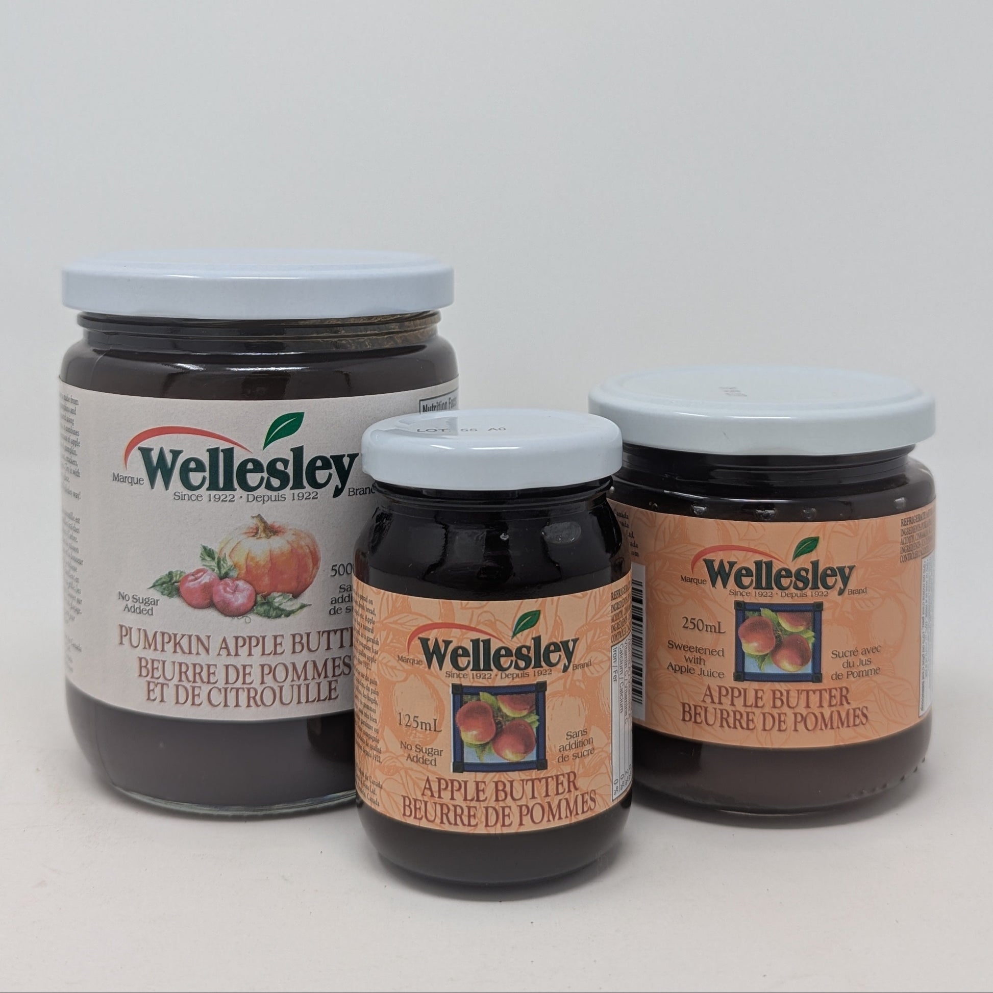 Three jars of Wellesley apple butter on a white background